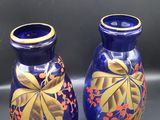 deux vases bleus ornés de motifs dorés, posés sur une table