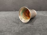 an old silver cup sitting on top of a black surface
