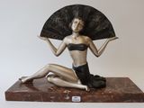 a statue of a woman with a fan on a marble base