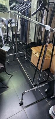 un portemanteau dans un magasin de vêtements, sur lequel sont posées des boîtes