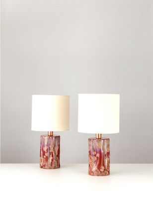 une paire de lampes en marbre posées sur une table, avec un abat-jour blanc