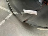 a sticker on the hood of a car that is parked in a parking lot