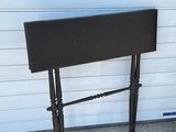 a black table with a black top on a sidewalk