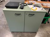 a green cabinet with a remote control on top of it