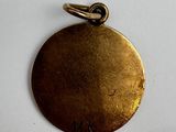 a close up of a gold medal with a black ribbon on a white surface