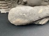 a statue of an angel holding a rock on a table