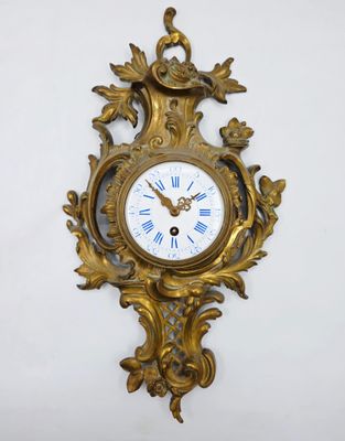 une horloge dorée accrochée au mur, avec des chiffres romains