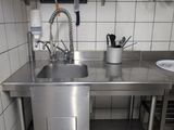 un évier en acier inoxydable dans une cuisine, à côté d'un plan de travail
