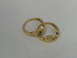 two gold wedding rings on a white surface