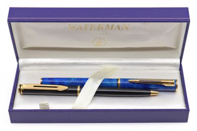 un stylo bleu dans une boîte violette ornée d'un ruban blanc