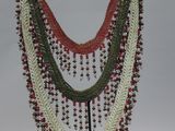 a multi - colored beaded necklace on a metal stand