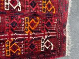 a red rug with a pattern on it on the floor