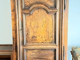 une grande armoire en bois dans une pièce où se trouve un banc