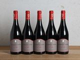 six bouteilles de vin rouge sont alignées sur une table en bois