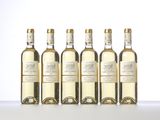six bottles of white wine are lined up on a table