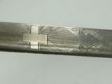 a knife with a cross on it sitting on a table
