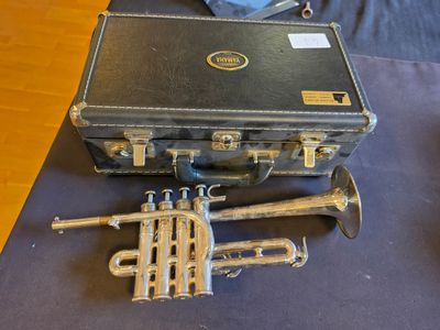 a suitcase with a trumpet and other musical instruments on a table