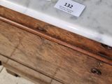 a white marble counter top with a wooden drawer underneath it