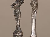 deux figurines en argent représentant une femme et un homme, posées sur une table