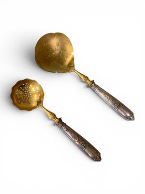 two spoons and a ladet are sitting on a white surface