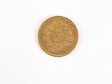 a gold coin on a white surface with a white background