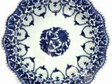 blue and white plate with a floral design on the rim