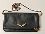 un sac à main noir orné d'ailes dorées