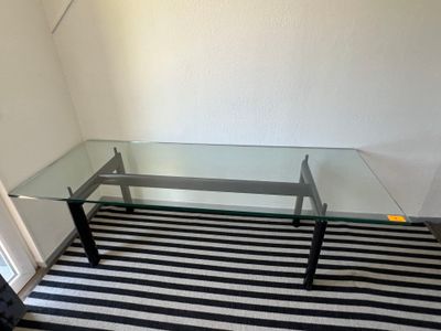 une table en verre avec un tapis rayé noir et blanc