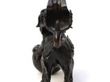 a small bronze statue of a dog on a white background