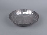 a silver plate with a scallop design on the rim