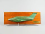 une maquette d'avion vert posée sur un socle en bois
