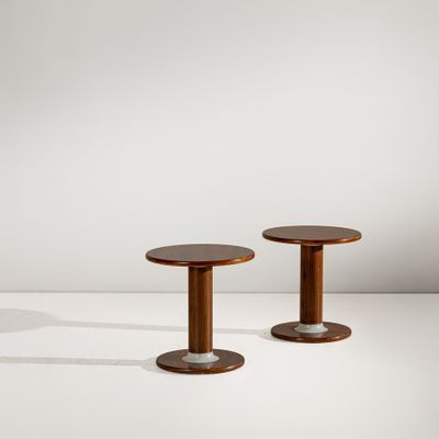 une paire de tables d'appoint rondes avec des pieds en bois et des pieds en métal