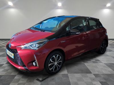 a red toyota yaris parked on a checkered floor