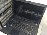 a laptop that is sitting on a table in front of a stack of electronics