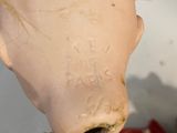 a close up of a doll with a gold chain around it ' s neck