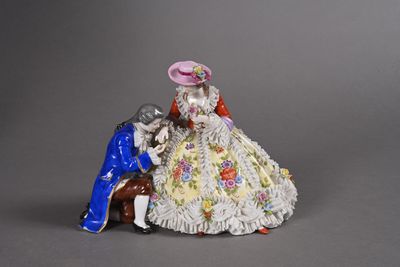 une figurine représentant un homme et une femme assis sur un banc