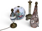 three vases and a lamp on a white surface