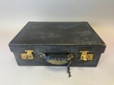 une valise noire munie d'un cadenas, posée sur une table