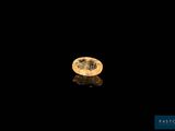 un diamant jaune sur une surface noire, avec un reflet