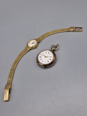 une image représentant une montre en or à laquelle est attachée une chaîne