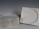 plusieurs assiettes blanches empilées les unes sur les autres sur une table