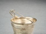 silver plated bucket with a spoon in it on a gray surface