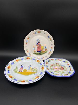trois assiettes ornées de motifs, posées sur une surface noire