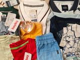 a lot of clothes that are on a bed