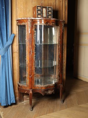 une vitrine en verre dans un coin de la pièce