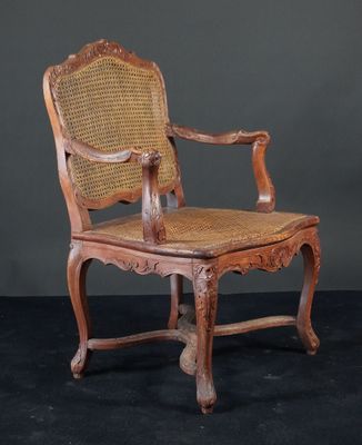 une vieille chaise en bois avec une assise en osier, sur fond noir