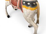 a small wooden horse with a saddle on it ' s back