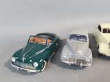 three toy cars sitting next to each other on a table
