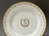 a white and gold plate with a gold decoration on it