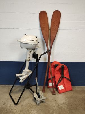 deux pagaies en bois à côté d'un moteur et d'un sac rouge